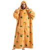 A woman wearing an oversized orange sherpa fleece blanket hoodie with a hood and fruit print.