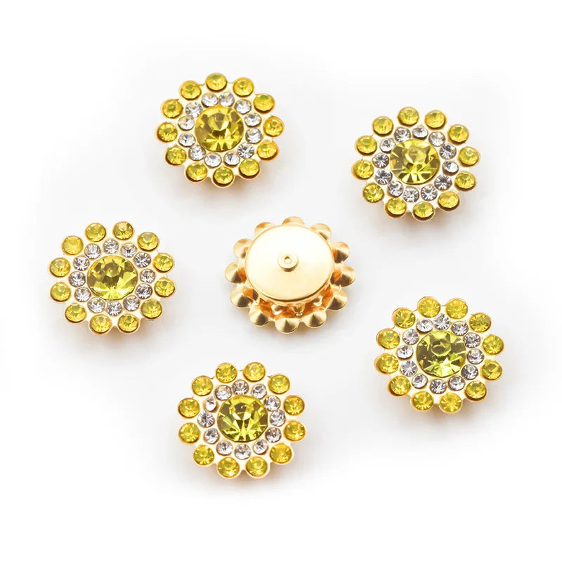 A collection of round, yellow-green and clear rhinestone crystals arranged in flower shapes on a white background.