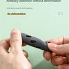 A hand holds a dark silicone pan handle cover, demonstrating its elasticity and ability to withstand distortion.