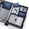 A set of six dark blue and gray travel packing cubes inside a black suitcase.