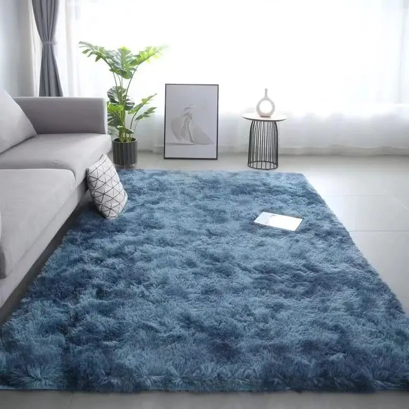 A fluffy blue tie-dye silk wool rug placed on a light floor in a bright room.