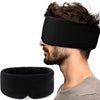 A man wearing a black 3D contoured travel sleep mask with a neck pillow for eye pressure relief.