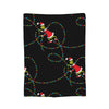 A black throw blanket decorated with colorful string lights and Christmas elf figures.