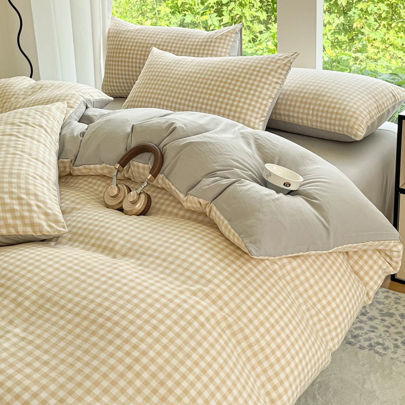 A beige and cream checkered duvet cover set with a soft gray throw pillow on a bed.