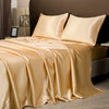 A luxurious satin bedding set in champagne gold color draped on a bed with neutral background.