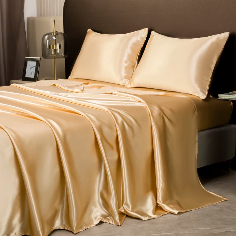 A luxurious satin bedding set in champagne gold color draped on a bed with neutral background.