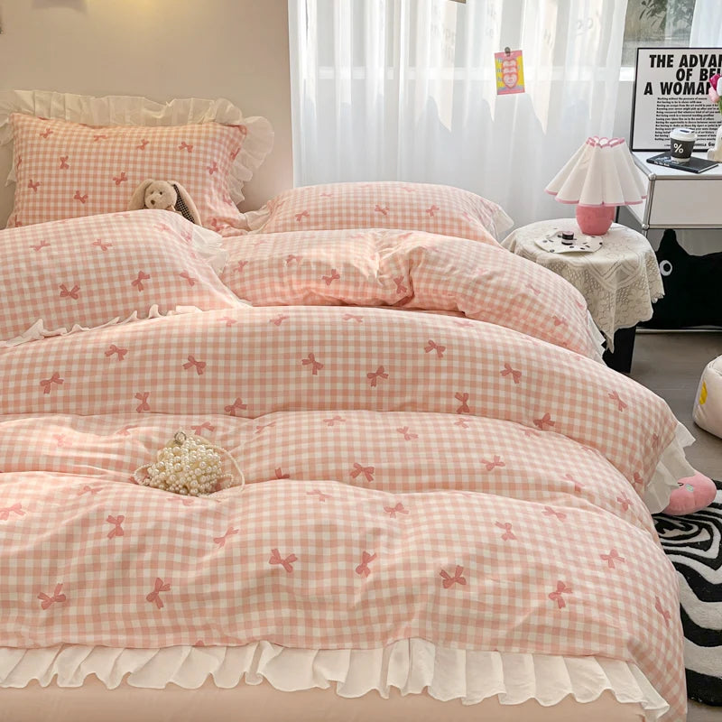 A set of pink and white floral bowknot duvet covers displayed on a bed with sheer curtains.