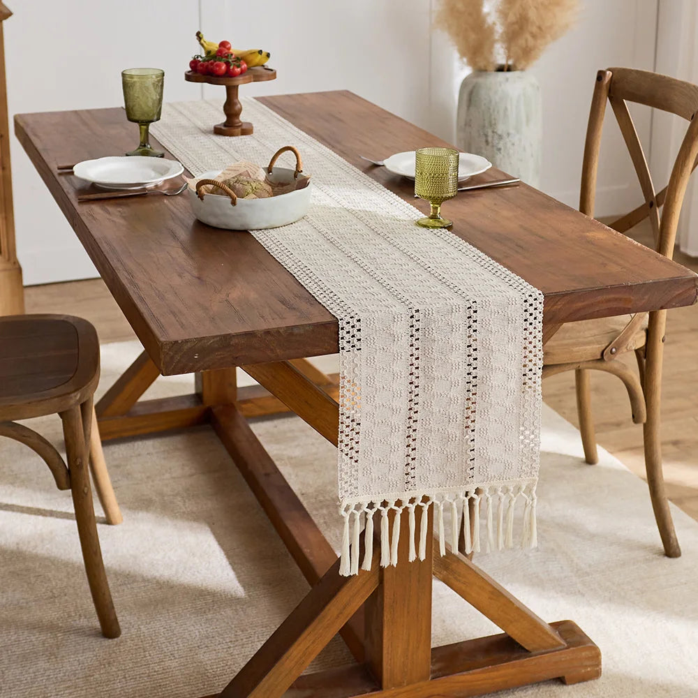 Beige boho hand-woven table runner placed on a wooden dining table with natural decor.