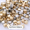 A pile of gold and silver heart-shaped acrylic beads for jewelry making