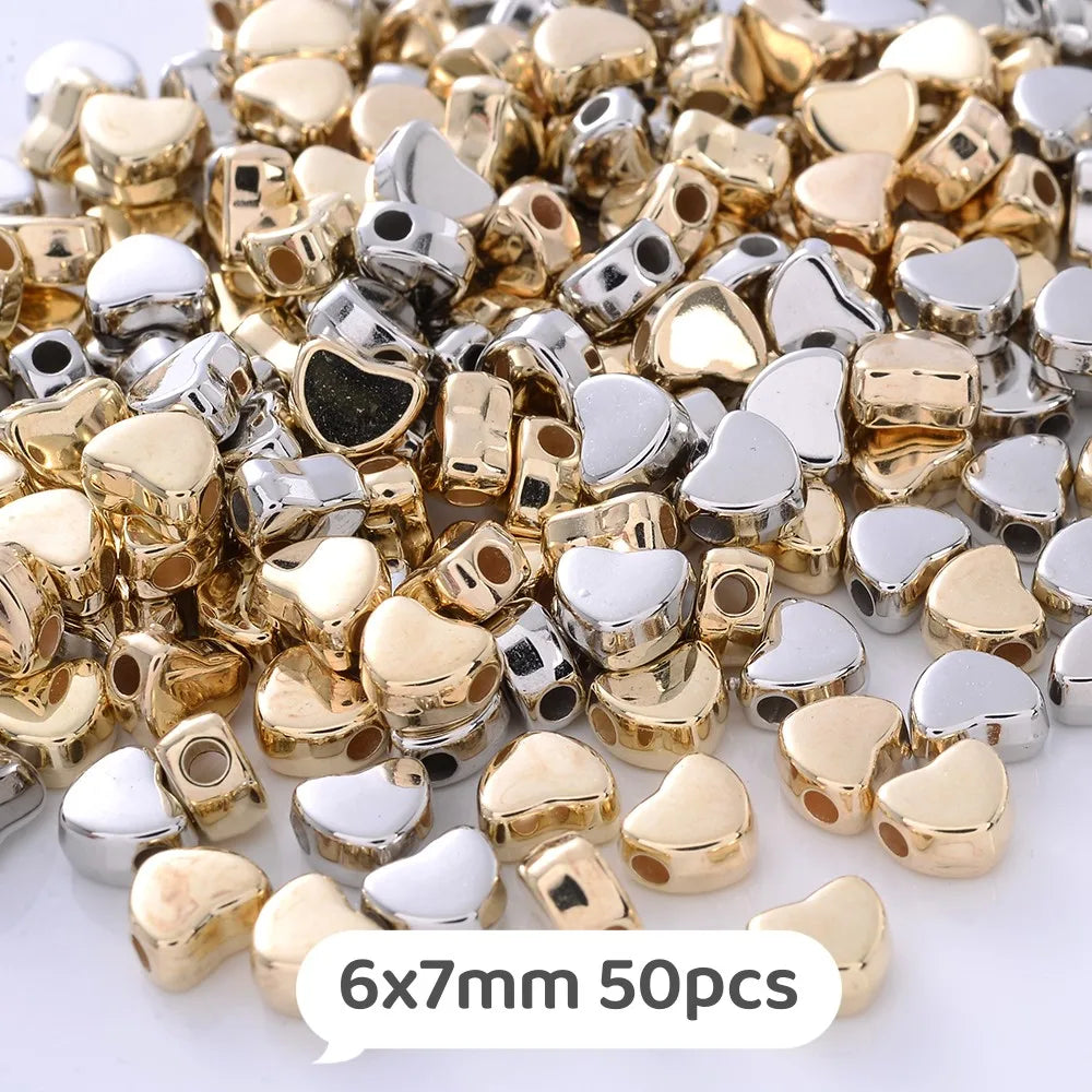 A pile of gold and silver heart-shaped acrylic beads for jewelry making