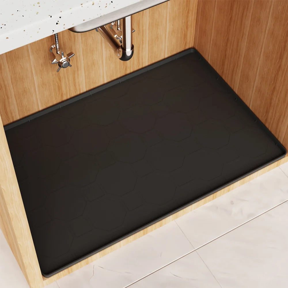 Black silicone liner mat placed inside a wooden under sink cabinet.
