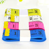 A set of two flexible body measuring tapes in yellow, pink, and blue colors with inch markings.