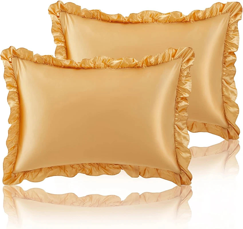 A set of two ruffled satin pillowcases in a golden beige color with silky envelope closures.
