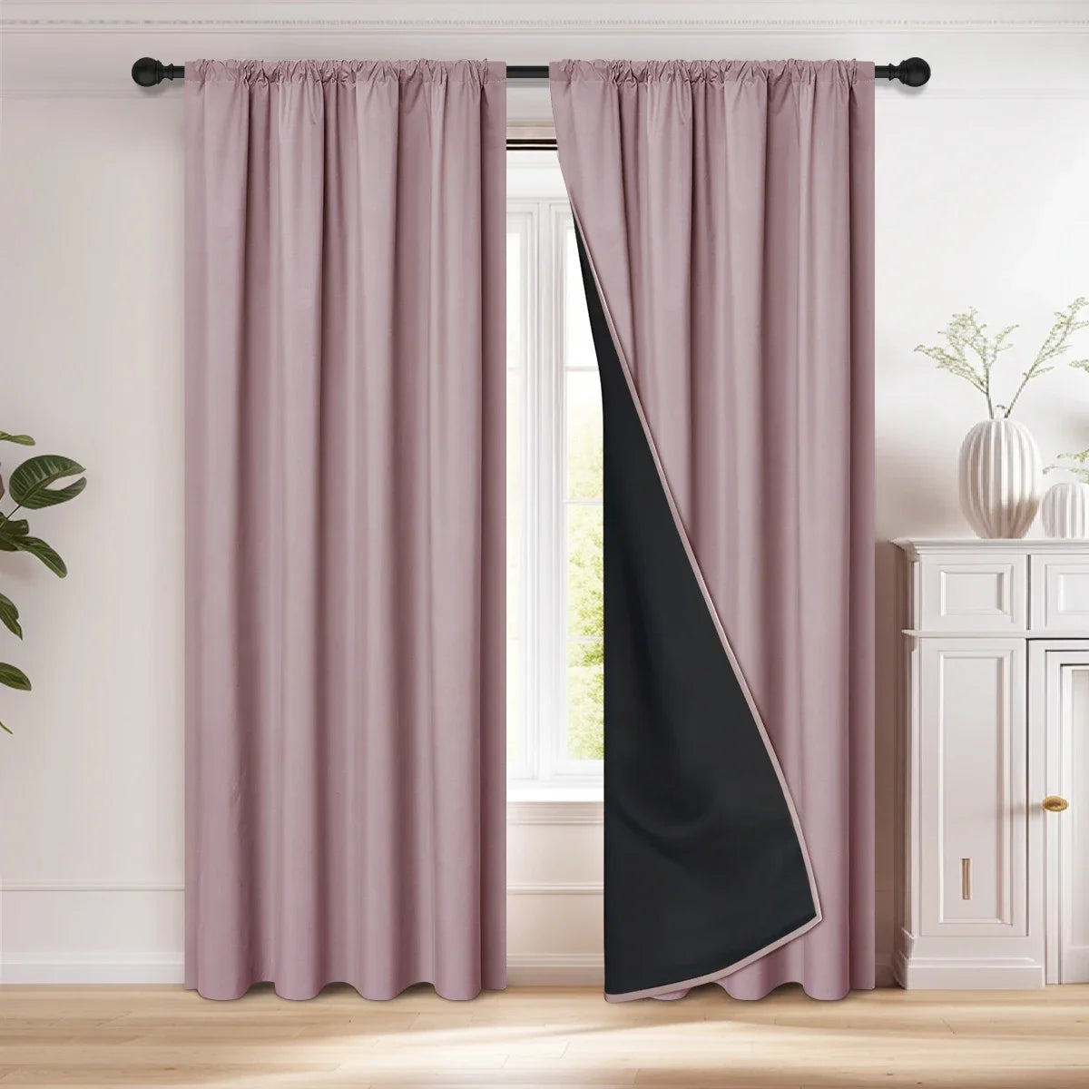 A pair of floor-length mauve curtains with a black diagonal panel hanging in a window frame.