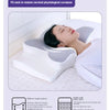 A person is using a white memory foam contour neck pillow to restore cervical physiological curvature while sleeping.