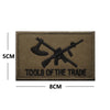 A rectangular brown embroidered patch featuring a black crossed tool design and the text TOOLS OF THE TRADE.
