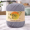 A skein of gray silk bamboo blend yarn is shown on a white surface with a label indicating premium quality.