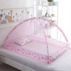 Pink foldable mosquito net covering an infant crib with decorative floral patterns.