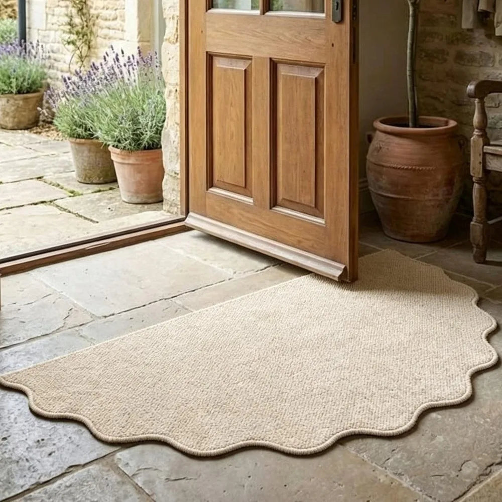 A natural jute non-slip entrance door mat placed on a stone floor near a wooden door.