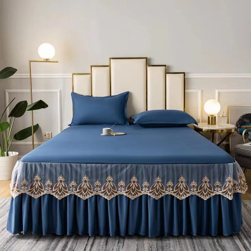 A royal blue embroidered cotton bedspread and pillow set displayed on a bed with gold accents.