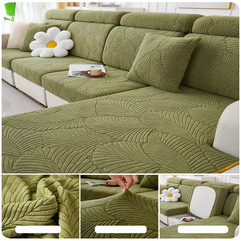 A textured olive green leaf jacquard stretch sofa cover displayed on a sectional sofa with white cushions.