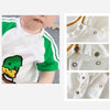 White and green short-sleeved shirt with a graphic design and snap buttons shown in detail.