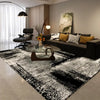 A black and white geometric non-slip area rug is displayed in a modern living room setting.