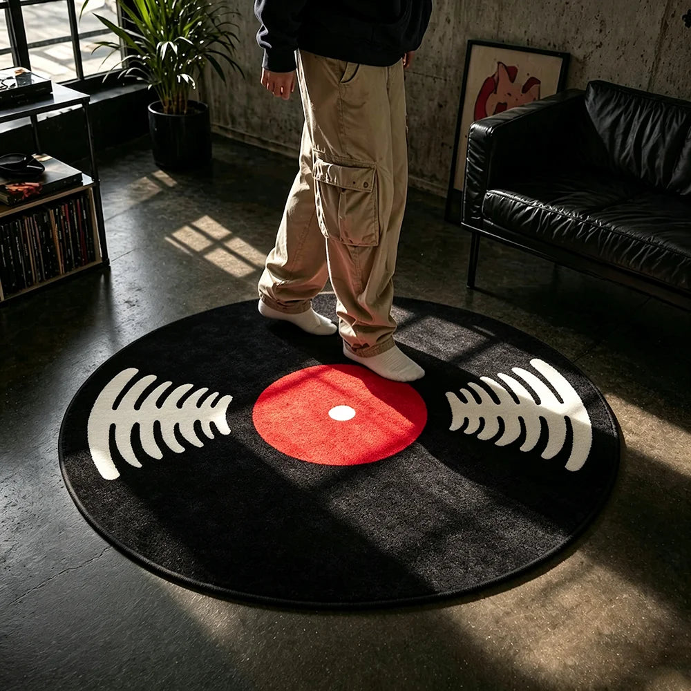 A round black rug with white sound wave patterns and a red center placed on a dark floor.