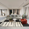 A Scandinavian geometric non-slip area rug featuring black and white stripes in a modern living space.