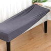A gray elastic stool cover is draped over a white sofa or seating cushion.