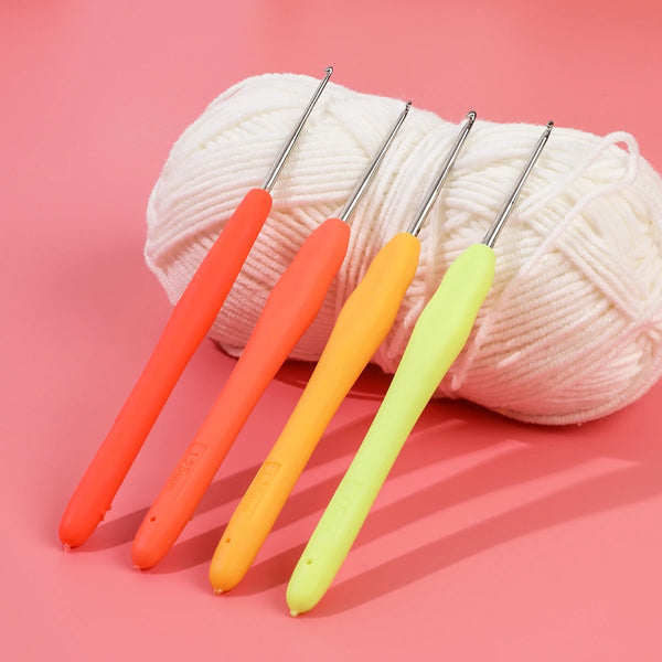 A set of five brightly colored aluminum plastic crochet hooks arranged diagonally on a pink background.