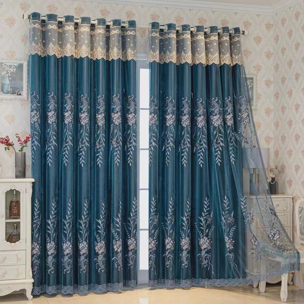 A pair of dark blue dual-layer curtains with white embroidered floral patterns hanging in a light-colored room.