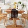 A wooden dining table set for a meal with a black crochet lace table runner and fringe.