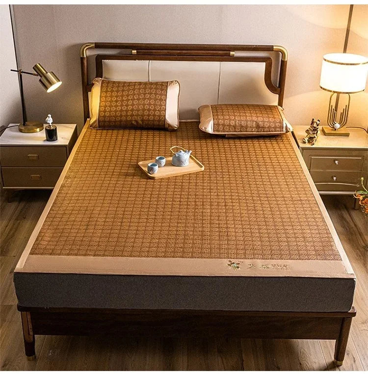 A natural bamboo cooling mat is displayed on a wooden bed frame with bedding and side tables.