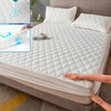 A white waterproof mattress protector fitted sheet is being placed onto a bed, with a close-up showing the fabric and a blue 