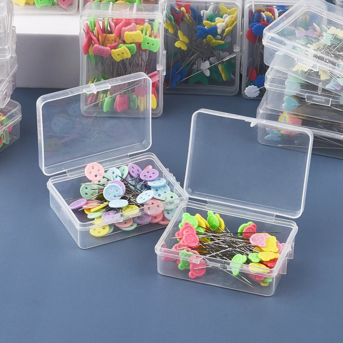 Clear plastic boxes filled with colorful nickel-plated dressmaking pins and various colored heads.