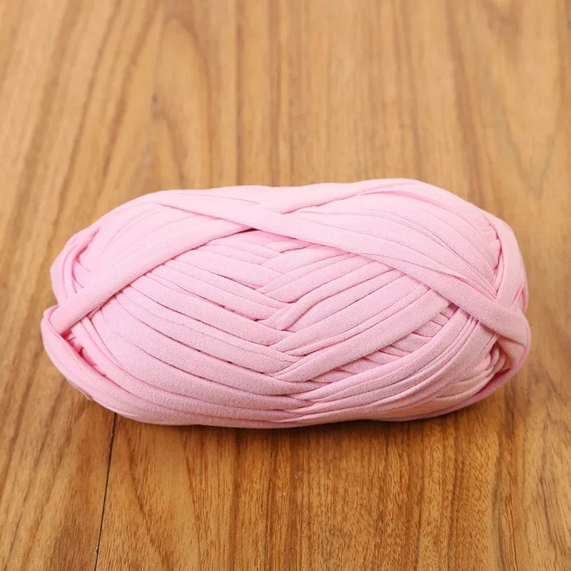 Pink flat thread yarn coiled into a ball for crafting and sewing