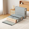 A light gray non-woven fabric storage box for bedding and clothing with a lid and storage slots on a wooden surface.