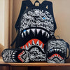 A black backpack and matching pouch featuring a white graphic print of a fierce dog's mouth.