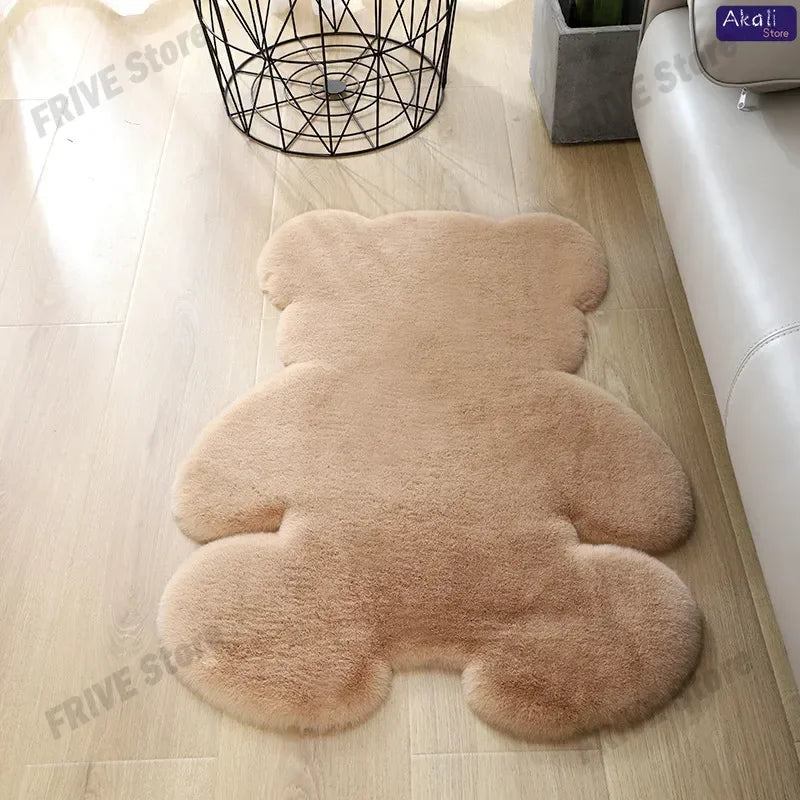 A light brown plush bear-shaped non-slip area rug lying on a wooden floor.