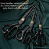 A set of heavy-duty carbon steel tailor scissors with black handles resting on a dark green fabric.