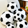 A collection of white and black realistic football plush toys are displayed on a light-colored surface.