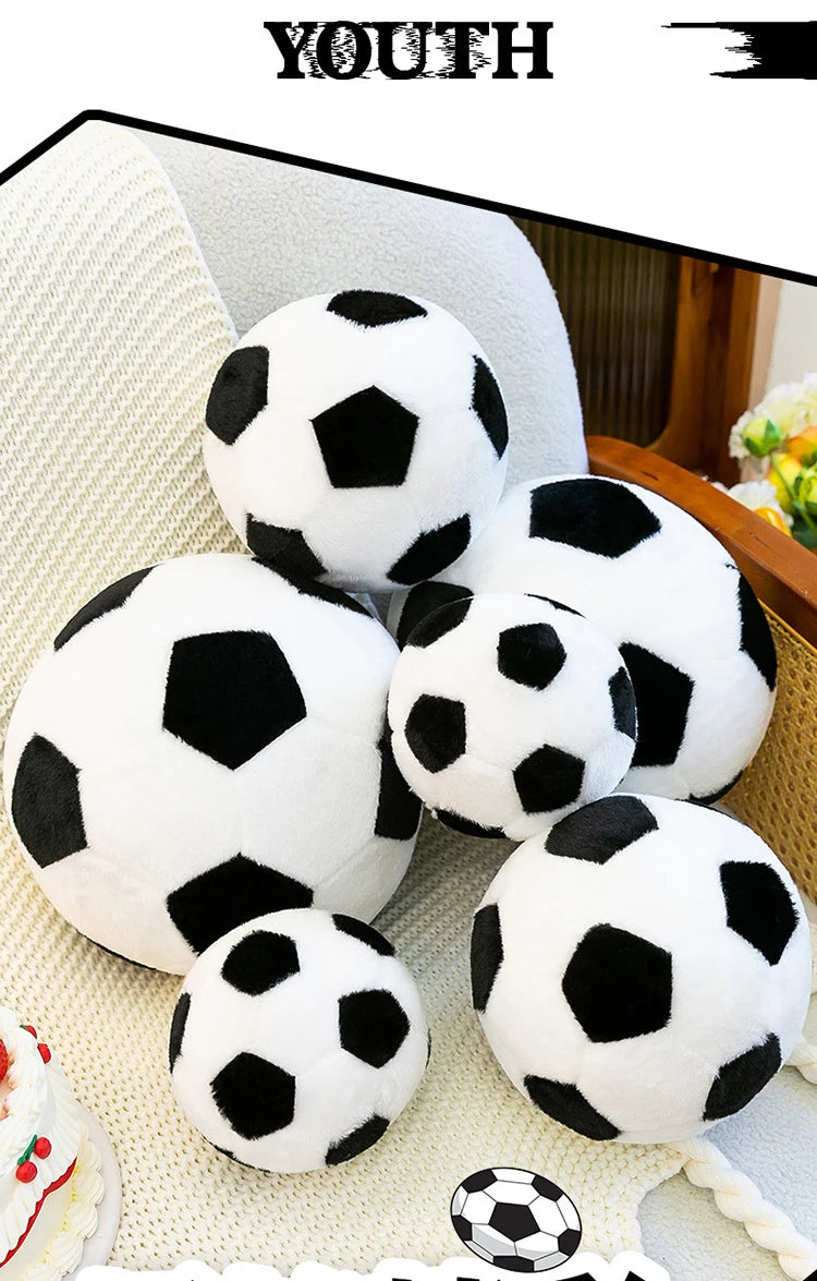 A collection of white and black realistic football plush toys are displayed on a light-colored surface.