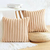 Two beige plush striped decorative pillowcases resting on a white surface.
