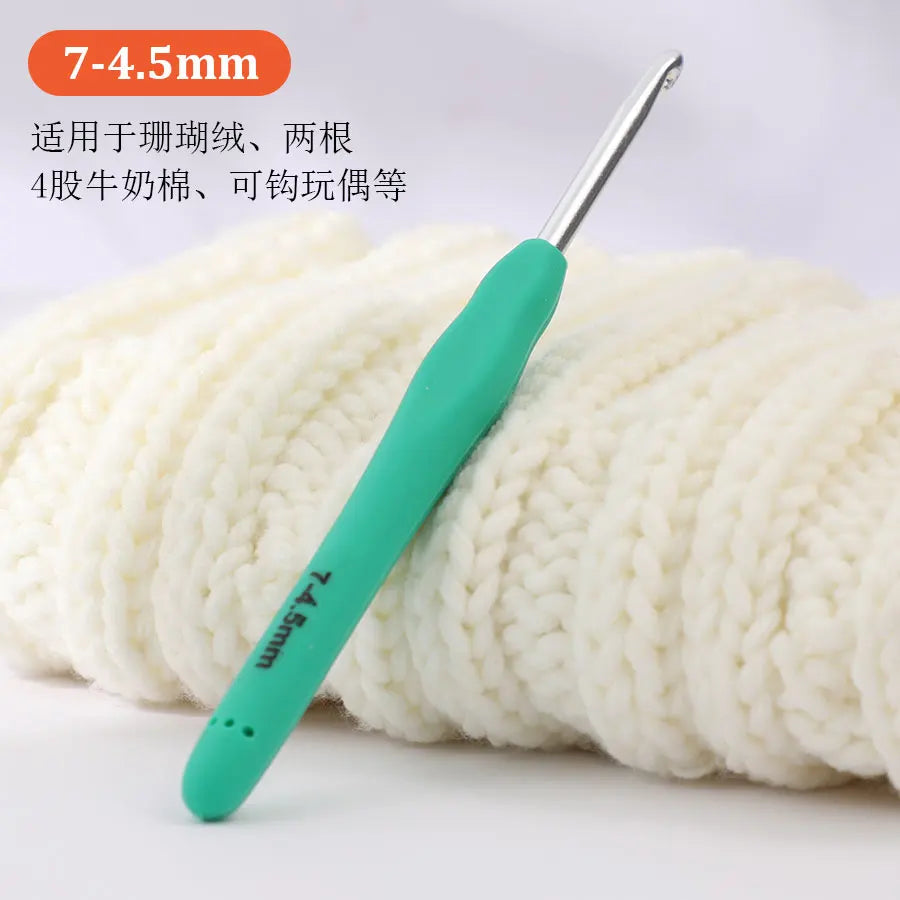 A pair of light green precision aluminum crochet hooks are shown next to a ball of white yarn.
