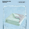 A folded light green summer quilt resting inside a block of ice, symbolizing lasting coolness.