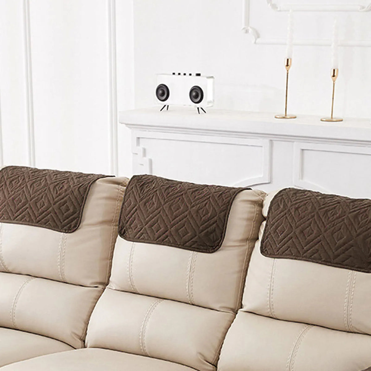 Three brown quilted headrest protector covers on a beige recliner seat.