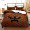 A brown patterned duvet cover set featuring a black eagle emblem on a bed.