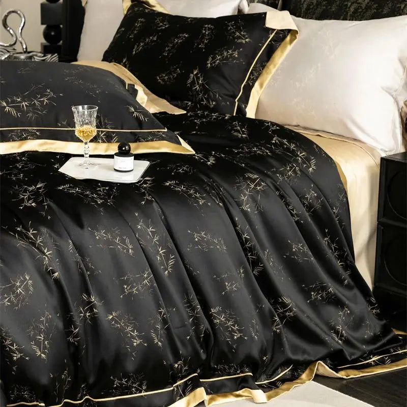 Black and gold luxury lyocell eucalyptus bedding set with a gold trim and glass of amber liquid
