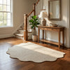 A natural jute non-slip entrance door mat placed on a wooden floor near a staircase and mirror.